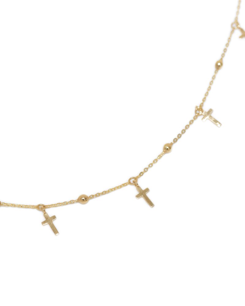 Close-up view of a gold chain bracelet curving gracefully across a white background, featuring small dangling cross charms and polished gold beads. 黃金手鍊特寫圖，展示於白色背景上呈弧線擺放的細鍊，鍊身綴有小型懸掛式十字架吊飾與亮面小金珠細節。