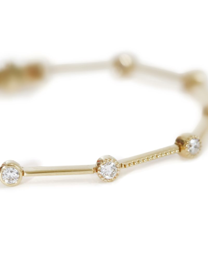 Close-up of a 18K/ 14K/ 9K gold bar link bracelet featuring bezel-set round diamonds on a white background. 18K/ 14K/ 9K黃金包鑲圓鑽手鍊特寫圖，展示由金屬長條相連的單顆圓鑽細節，純白背景。